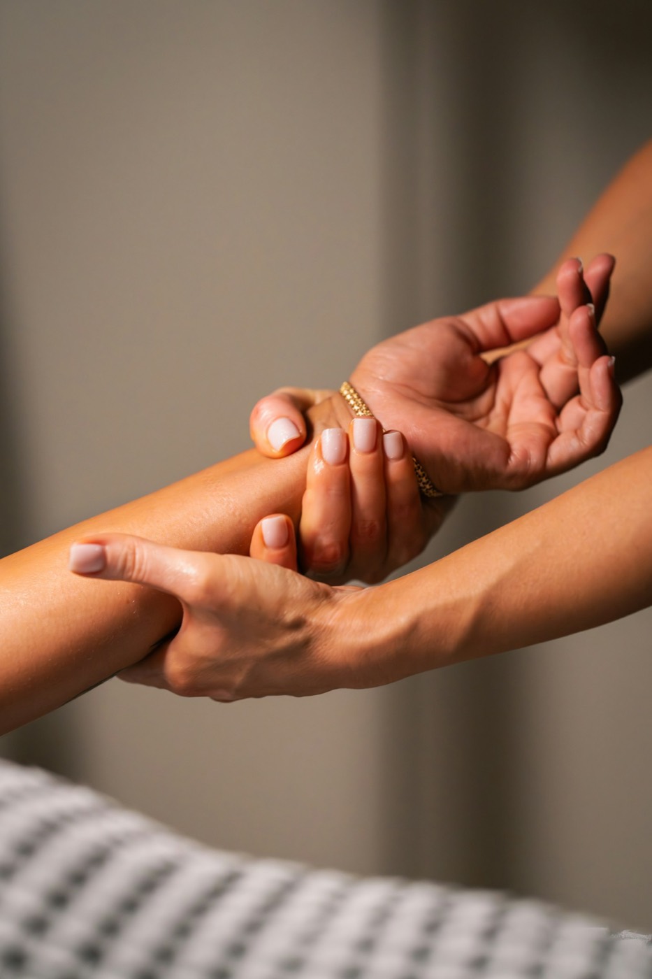 Mains d'une masseuse sur l'avant-bras d'une cliente